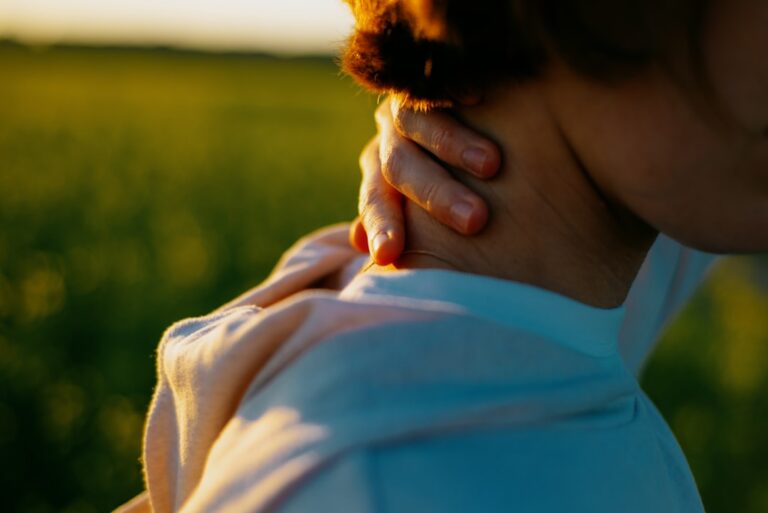 Woman holding her neck in pain, illustrating cervical radiculopathy symptoms