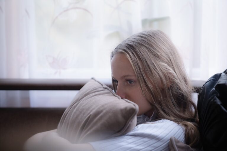 Woman sleeping on her side hugging a pillow
