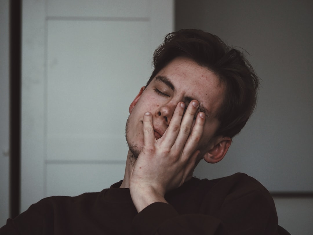Tired person rubbing their eyes in bed in the morning